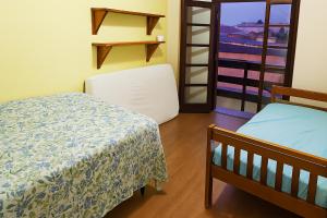 Cette petite chambre comprend deux lits et un balcon. dans l'établissement casa do fred enseada, à Guarujá 6 autres photos