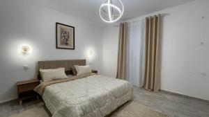 a bedroom with a bed and a chandelier at ZENHOME luxury appartement in Dilida