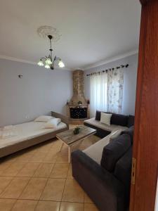 a living room with a couch and a table at Maison de Fabjon in Ksamil