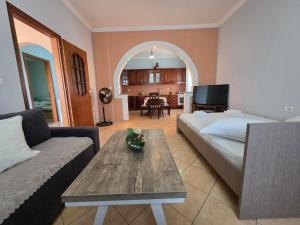 a bedroom with a bed and a couch and a table at Maison de Fabjon in Ksamil