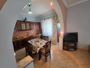 a kitchen and dining room with a table and a television at Maison de Fabjon in Ksamil