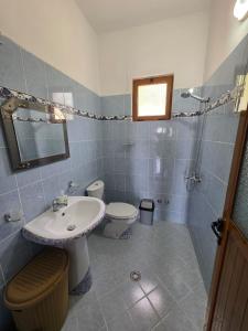 a bathroom with a sink and a toilet at Maison de Fabjon in Ksamil +6 photos