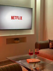 a living room with a television and two wine glasses at ZENHOME luxury appartement in Dilida