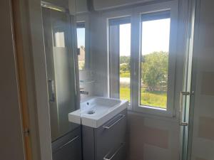 a white bathroom with a sink and a window at Parenthèse à la Maison de l'Ecrivain entre nature et petit déjeuner festin in Servon