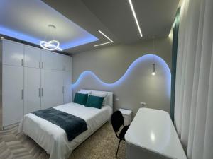 a bedroom with a white bed with a blue accentuation at Urban Luxe Retreat- Pogradec in Pogradec