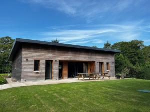 a wooden building with a picnic table in a yard at Maison Osithe in Doudeauville