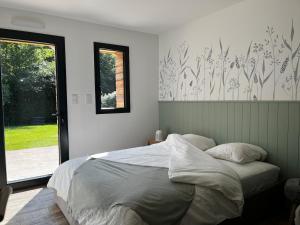 a bedroom with a large bed and a window at Maison Osithe in Doudeauville