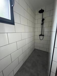 a shower with white tiled walls and a spotlight at Maison Osithe in Doudeauville +34 photos