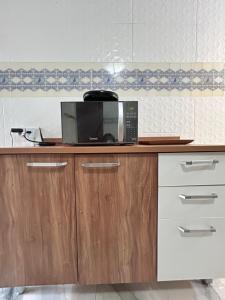 a microwave sitting on top of a kitchen counter at Brisa Do mar Apartamento 2 in Cabo Frio