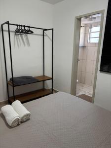 a bedroom with a bed with two towels and a shower at Apartmento Valencia in Franca +4 photos