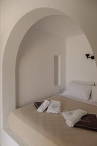 a white bedroom with two towels on a bed at VERANNA Patmos D4 in Patmos