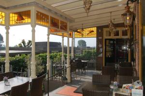 ein Restaurant mit Tischen und Stühlen auf einer Terrasse in der Unterkunft 't Oude Veerhuis in Heerewaarden