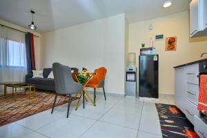a living room with a couch and a table and chairs at 1 Bedroom Apartment in Syokimau near Airport and SGR in Nairobi