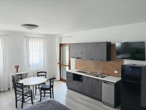 a kitchen with a table and a kitchen with a table and chairs at Agriturismo Al Preve in Ponzano Veneto