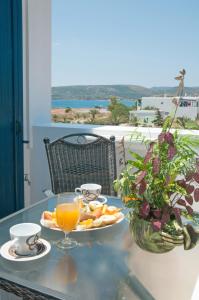 a table with a plate of food and a glass of orange juice at Anastasia Studios in Avlemonas