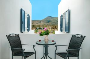 a table with two chairs and a vase with flowers at Anastasia Studios in Avlemonas