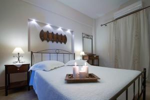 a bedroom with a bed with two candles on it at Anastasia Studios in Avlemonas
