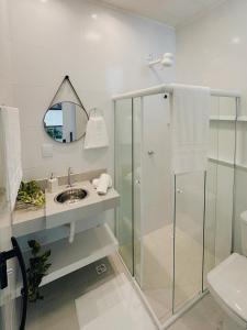 a bathroom with a shower and a sink and a mirror at Loft Aconchegante & bem localizado VI in Feira de Santana