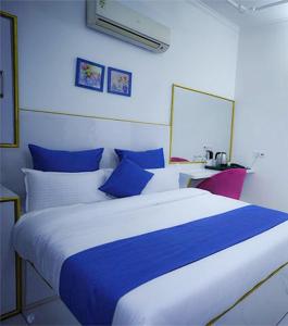 a blue and white bedroom with a large bed at The Host By Amaris in Amritsar