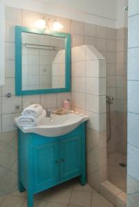 a bathroom with a blue sink and a shower at Anastasia Studios in Avlemonas
