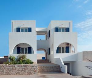 a white house with arched windows on the side at Anastasia Studios in Avlemonas