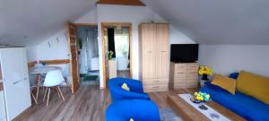 a living room with a blue couch and a television at Mieszkanko z tarasem in Limanowa