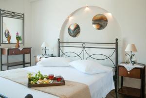 a bedroom with a bed with a tray of food on it at Anastasia Studios in Avlemonas