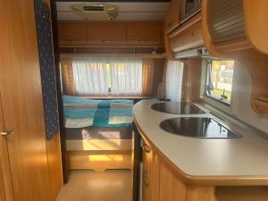 a kitchen with a sink and a bed in a trailer at Camping Alex in Cadenazzo