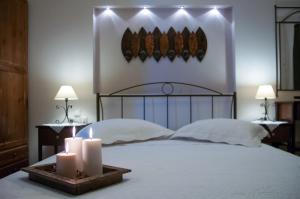 a bedroom with a bed with two candles and two lamps at Anastasia Studios in Avlemonas