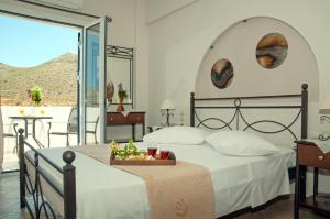 a bedroom with a large bed and a balcony at Anastasia Studios in Avlemonas