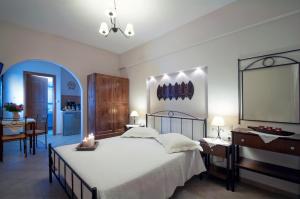 a bedroom with a large bed and a table and a desk at Anastasia Studios in Avlemonas