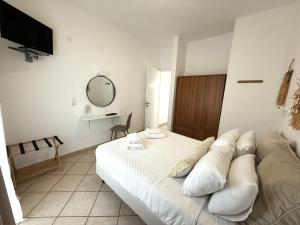 a bedroom with a bed with pillows and a mirror at Fabrika Apartments in Vári
