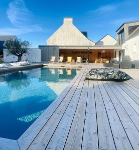 カランテックにあるVilla le 25 - Piscine et Sauna au bourg de Carantecの木製デッキ付きのスイミングプールが隣接しています。