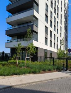 een hoog wit gebouw met bomen ervoor bij GoldClass Apartament in Katowice +15 foto's