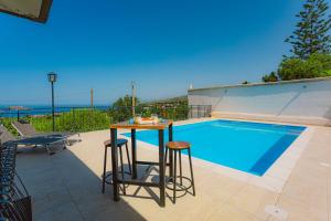a pool with a table and two stools next to it at villa ulivo rovetto in Mandra Capreria