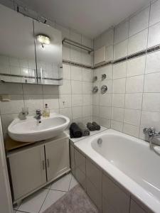 a white bathroom with a sink and a tub at Herzensnest mit Grüntenblick in Immenstadt in Immenstadt im Allgäu
