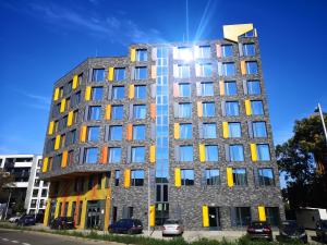 a tall building with yellow and blue windows at Magnolia Loft Apartments in Wrocław