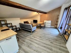 a living room with a couch and a table at Grand T3 Wifi 2 chambres 82m2 centre Foix stationnement devant le logement in Foix