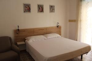 a bedroom with a white bed and a chair at Ida's house in Formia