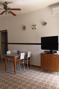 a dining room with a table and a flat screen tv at Ida's house in Formia