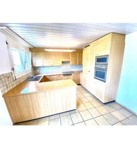 a kitchen with wooden cabinets and a counter top at Private room in Schänis for more than 3 guests the entire place is yours in Schänis