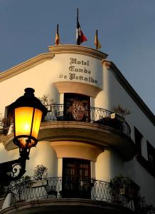 un edificio con un reloj en él con una luz de la calle en Hotel Conde de Penalba en Santo Domingo