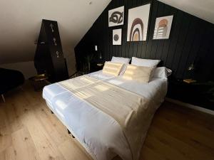 a bedroom with a large bed with white sheets and pillows at La Suite by M votre escapade amoureuse in Beaudignies