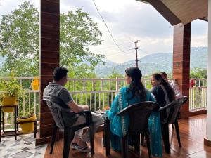 a group of people sitting on the porch of a house at TownHill Homestay in Bhīm Tāl +9 photos