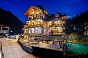 マナリにあるHotel Valley Vista Manaliの照明付きの大きな木造建築