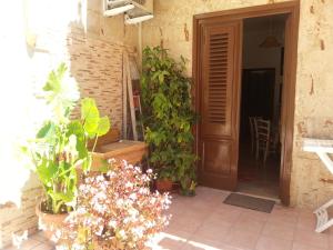 a patio with plants and a wooden door at Casa Vacanze Salinisti in Marsala