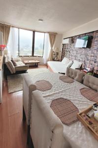a living room with a large bed and a couch at Lindo departamento Edificio Centro Mayor in Temuco +4 photos
