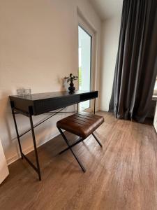 a desk with a chair in a room with a window at Bluemango Signature Apartment No 6 - direkt neben der Messe Essen in Essen