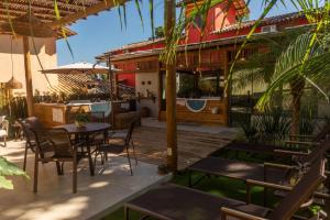a patio with a table and chairs and a building at Villa Maritaca Condomínio de 4 Casas de Locação por Temporada de Alto Padrão com SPA in Arraial d'Ajuda