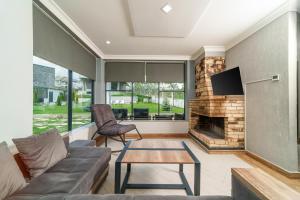 迪利然Cinema Pool & Hot Tub Luxe White Villa Dilijan的带沙发和壁炉的客厅